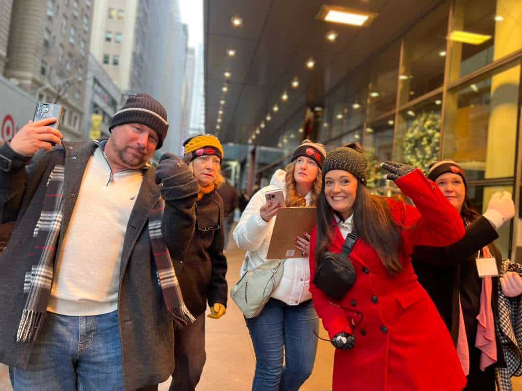Corporate group solving clues during a live-hosted team building scavenger hunt in Times Square, New York City